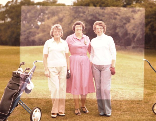 3 older women golfers on a golf course in a sun faded photograph