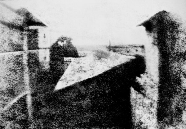 A black and white old photo in very low resolution featuring a view from a window at Le Gras