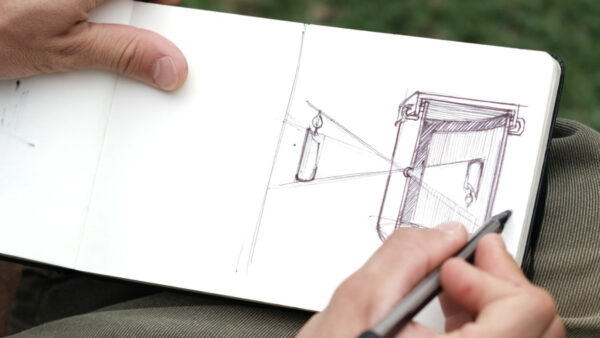 An open sketchbook featuring a drawing demonstrating the workings of a camera obscura