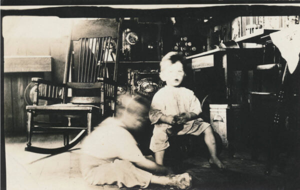 Motion blurred photo of two young boys playing in a vintage living room
