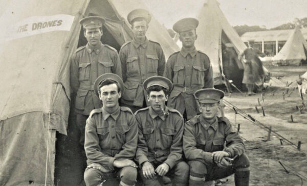 World War 1 soldiers posing for photo in front of a camp tent